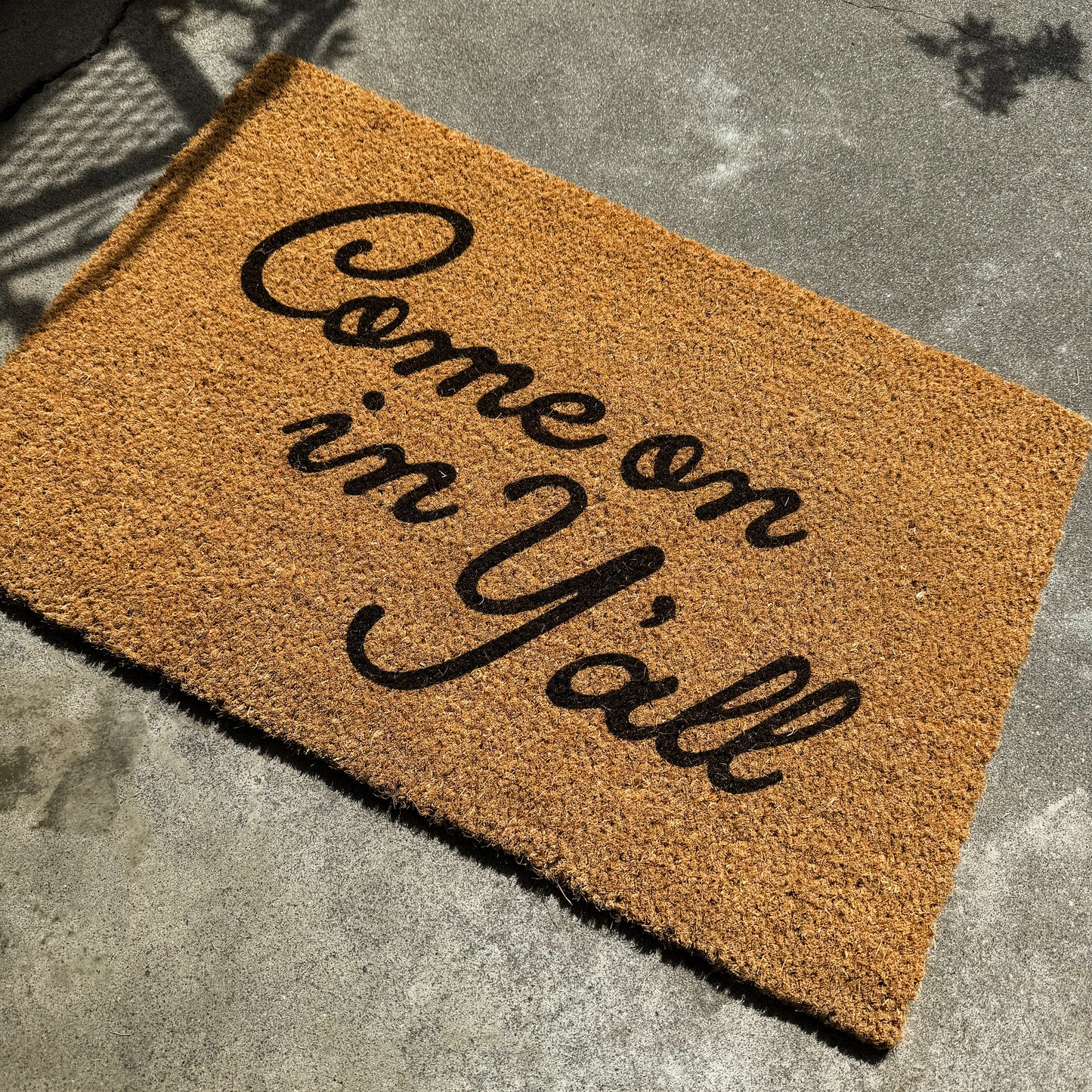 Doormat with 'Come on im Y'all' text on a concrete floor